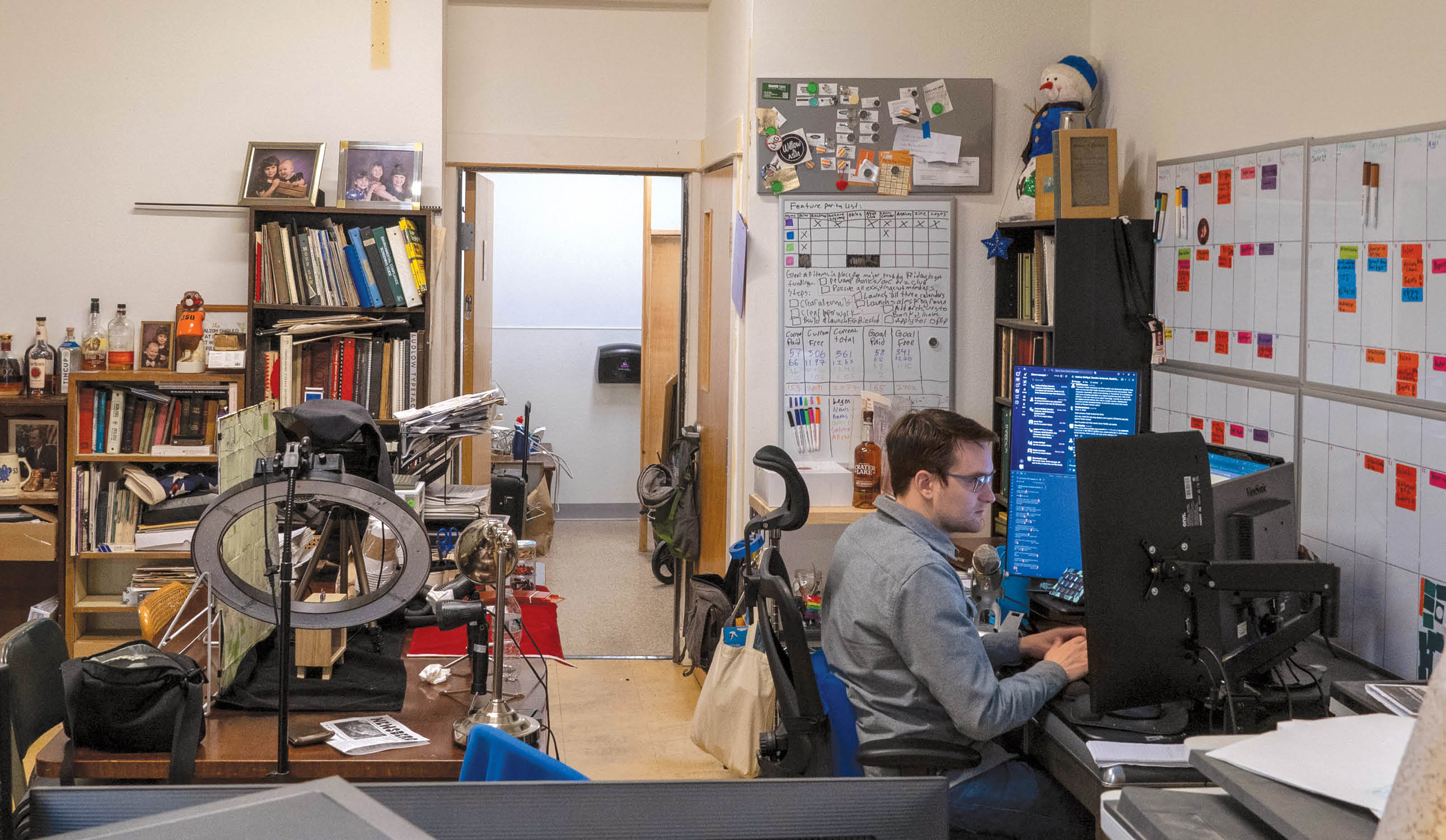 A photo of Chas Hundley at work in his crowded home office