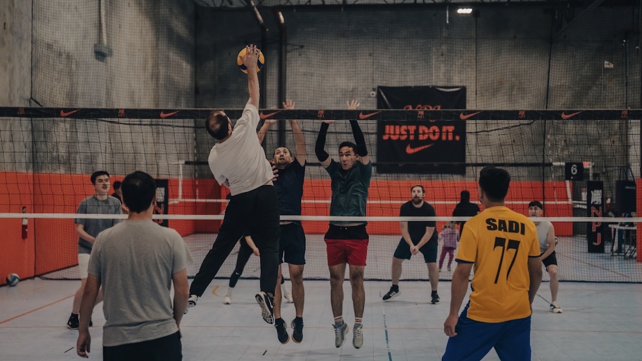 Several Afghan men playing volleyball at a Salem community center