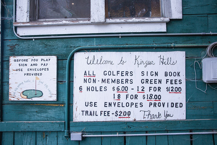 A photo of a sign at the Kinzua Hills clubhouse showing prices for players ($6 for six holes).